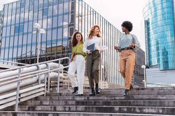 Confident businesspersons talking in front of modern office building. Businesswoman have business conversation. Banking and financial market concept