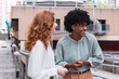 © BUDDHA - Two trendy businesswomen talking and laughing casually outside