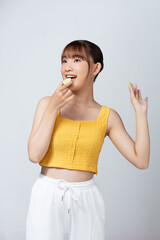 Beautiful young woman with cucumber slices on light background