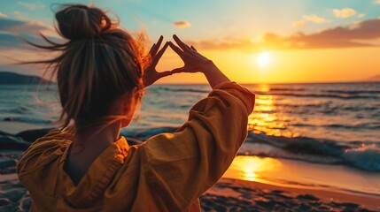 Wall Mural - Travel planning concept, Close up of tourist woman hands making frame gesture on the sea beach with sunset, Female capturing the sunrise