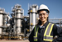 Smiling Female Engineer Wearing Hard Hat And Safety Glasses At An Industrial Facility