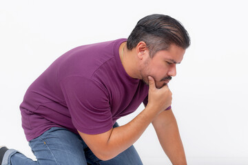 A curious man kneeling, looking at something at the ground trying to figure it out. Isolated on a white background.