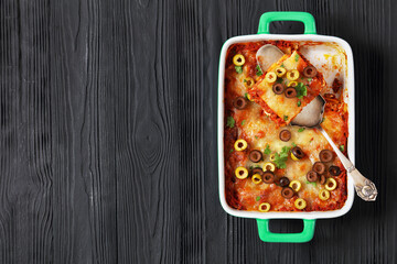 Wall Mural - lasagna with olive rings in green baking dish