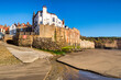 Robin Hood's Bay, the sea wall and village, North Yorkshire, from the foreshore on a spring morning.