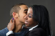 Mother of a young man receives a kiss on the cheek from him.