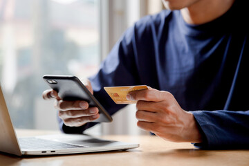 man holding credit card and using smartphone at home online shopping ecommerce internet banking spen