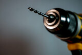 Fototapeta  - Electric drill, screwdriver with a dull metal drill bit close up shot, space for text.