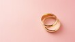 Pink pastel background with copy space and wedding golden rings