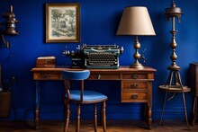 A Vintage Writing Desk With A Vintage Lamp And An Antique Typewriter Against A Royal Blue Wall.