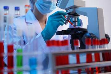 Science test tubes, laboratory equipment for new medical research, microbiology research with small pipettes in close-up. Asian and African female scientists in the laboratory, perfume samples