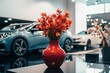 Ceramic vase holds fake red flowers on a glass table, showroom elegance.