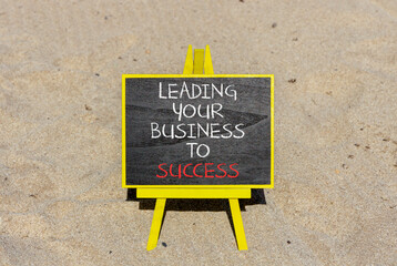 Wall Mural - Leading your business to success symbol. Concept words Leading your business to success on beautiful blackboard. Beautiful sand beach background. Leading your business to success concept. Copy space