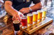 © Art Meripol - Mans hands reach in to try a flight of beers in a brewery