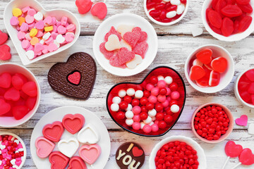 Wall Mural - Valentines Day candy table scene with an assortment of sweets. Above view on a white wood background.