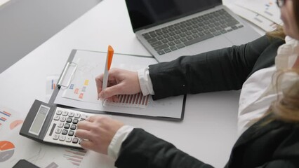Poster - A financial analyst keeps records and analyzes data in the workplace using modern technology and a calculator. A female accountant works intently on preparing financial reports and making calculations