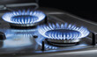 Blue flames of a gas burner on a kitchen stove dark background close up