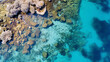 An aerial view of a coral reef in clear blue ocean waters.
