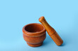 Wooden mortar and pestle on blue background