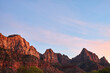 Mountain peaks painted red by the setting sun. The far right peak is the famous watchman.
