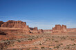 Road leads through the various monument looking rock formations, hoodos, and sparse desert of Arches National Park