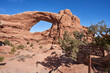 A trail marker sign points to the south window arch of Arches National Park. It also points to the primitive trail.