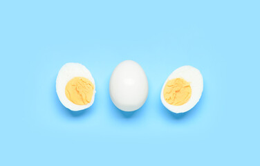 Tasty boiled egg with halves on blue background