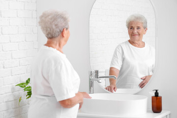 Sticker - Senior woman looking in mirror at home