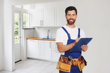 Wall Mural - Plumber with clipboard and tool belt in kitchen, space for text