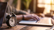 © AspctStyle - Close up of alarm clock on forefront with entrepreneur work on laptop in office on background, working process, workday, time management concept