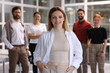 © New Africa - Portrait of happy businesswoman and her team in office