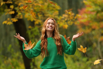 Poster - Autumn vibes. Happy woman throwing leaves up in park