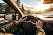 © Uliana - The hands of a car driver firmly gripping the steering wheel during a road trip, navigating through a highway landscape.
