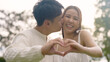 © ChayTee - Young asia people happy lover flirt fall in love care trust hand sign tender symbol. Just married sweet time comfort asian couple life man woman relax smile showing finger heart shape look at camera.