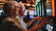 © Jammy Jean - Senior couple having fun inside a casino, using slot machines.
