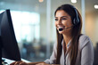 © Mongkol - Customer support with this image of a professional woman using headphones and microphone at a computer, symbolizing efficient call center service.