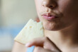 Crop teenage girl holding eaten cheese slice at home