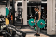 © Dusan Petkovic - A female bodybuilder is doing exercises with barbell in a gym.
