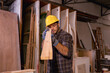 © Wanwajee - Horizontal image of Young White man carpenter labor, craftman working in wood workshop together, looking follow by peice of work furniture industry.