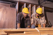 © Wanwajee - Young affrican american and white men carpenter labor, craftman working in wood workshop together, looking work peice. Timber industry and furniture industry.