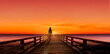 Silhouette einer Frau auf einem Landungssteg bei Sonnenuntergang am Meer