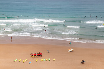 Wall Mural - Biarritz, France. Aerial view of the beach. Surfers training on the beach and in the ocean. Active holidays. 