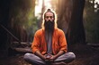 Bearded man in orange robe meditating in forest