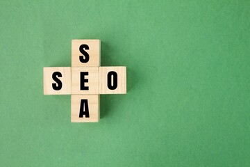wooden square with the letters sea and seo. search engine optimization and search engine advertising