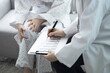 © 상은 신 - Medium distance frontal shot of medical professional taking notes during patient consultation