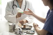 © 상은 신 - Close-up side angle shot of doctor handing medication to patient with medical supplies on table