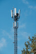 Closeup of a modern communications tower with bright blue sky in the background.
