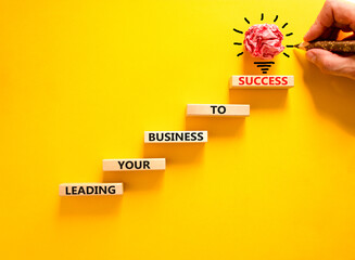 Wall Mural - Leading your business to success symbol. Concept words Leading your business to success on wooden blocks. Beautiful yellow table yellow background. Leading your business to success concept. Copy space