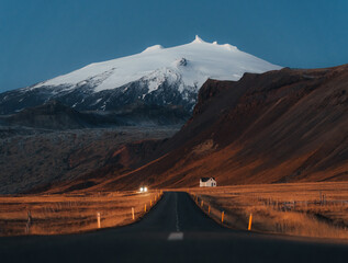 quiet road towards a huge volcanic mountain in the distance, near Snaefellsjokull national park, Iceland.