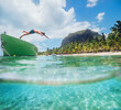 © Soloviova Liudmyla - Jumping teenage boy from wooden boat snorkeling in clean turquoise lagoon on Le Morne palm trees beach with Le Morne Brabant mount. Mauritius island. Exotic traveling and vacation concept.