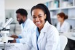 © Dara - Smiling African American female doctor, working coworkers, laboratory background photo